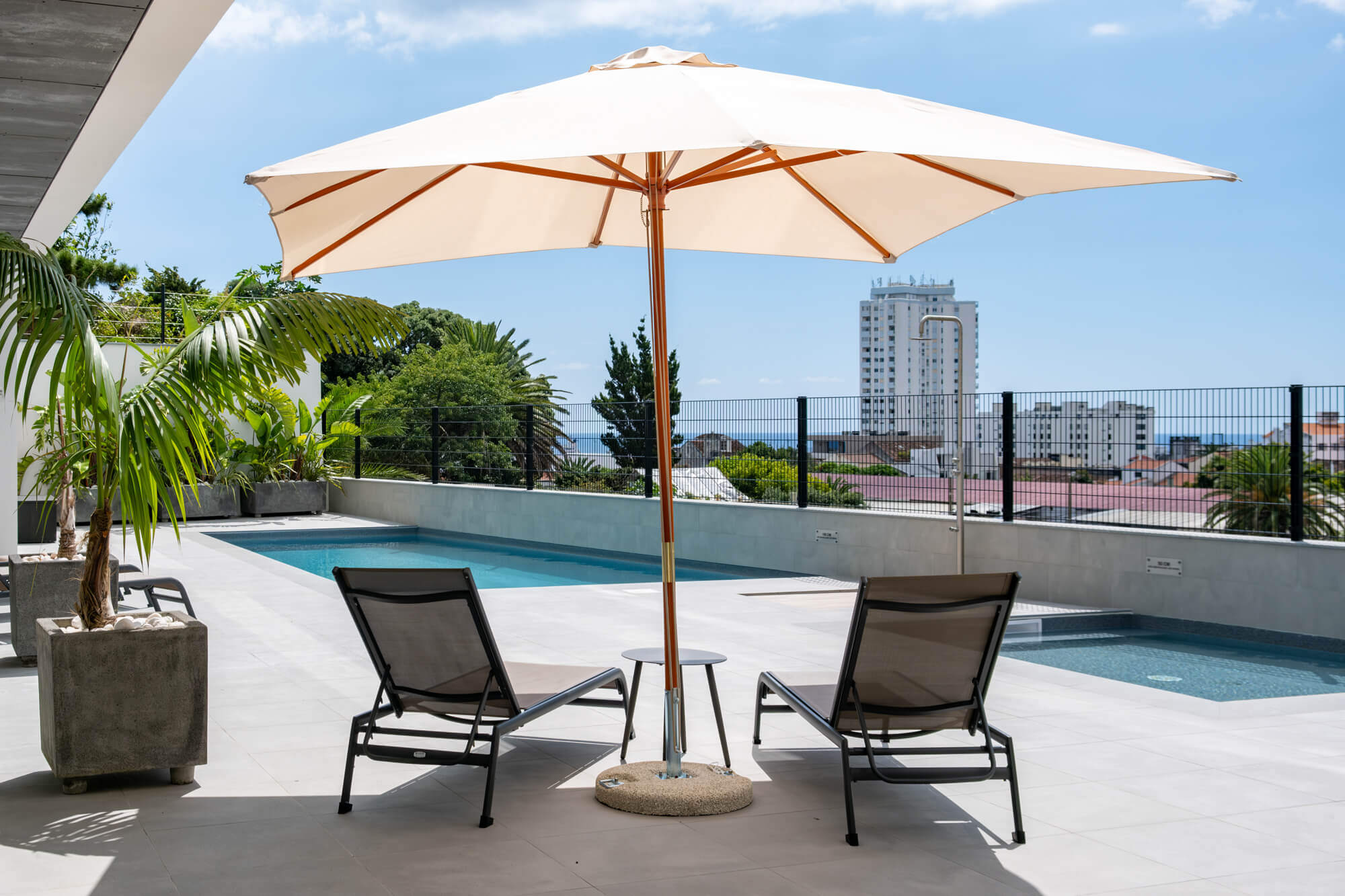 Terraço do Alto do Forte com espreguiçadeiras, chapéu de sol e vista para o mar
